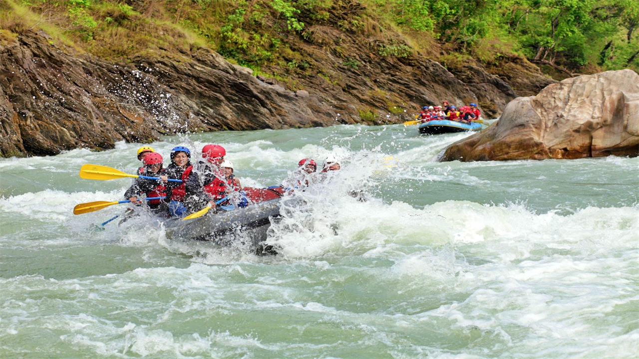 Is It Safe to Travel in Costa Rica Image: A group of whitewater rafters is seen laughing, smiling, and having fun.