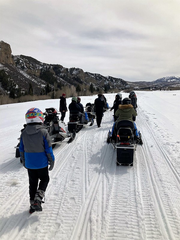 a group of people preparing for a snowmobile tour in utah