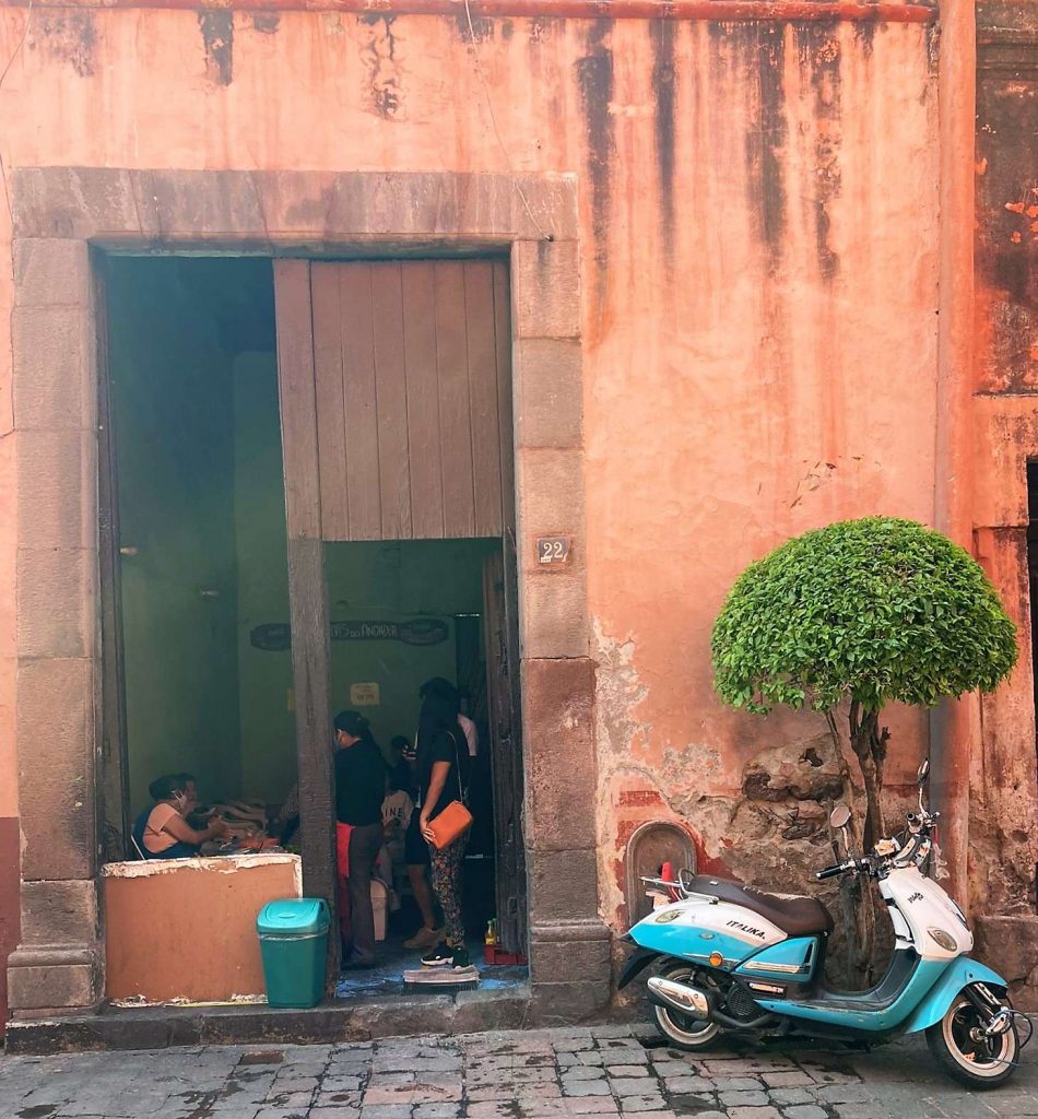 a bike in front of old building with people inside in queretaro