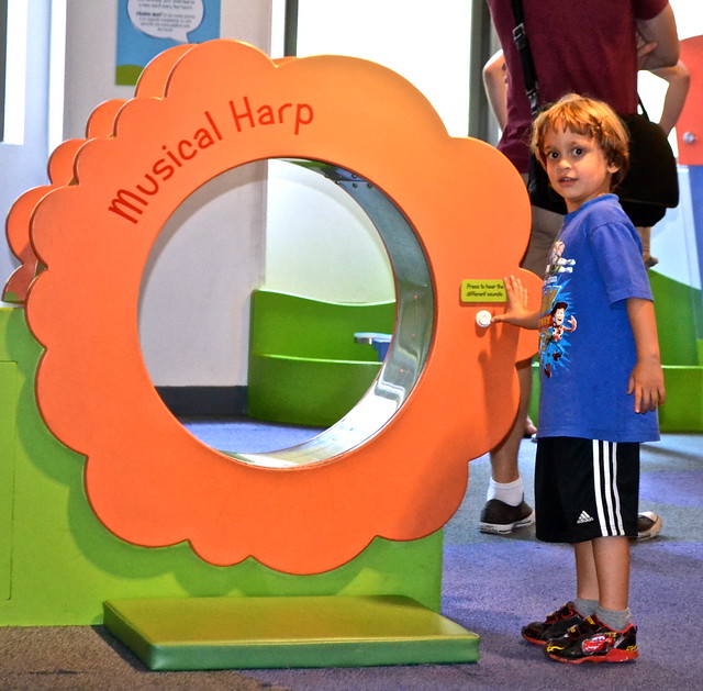 kid playing with a musical harp at children's museum in manhattan new york 