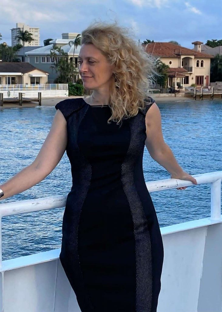 blonde woman wearing a black dress on a yacht in fort lauderdale canal