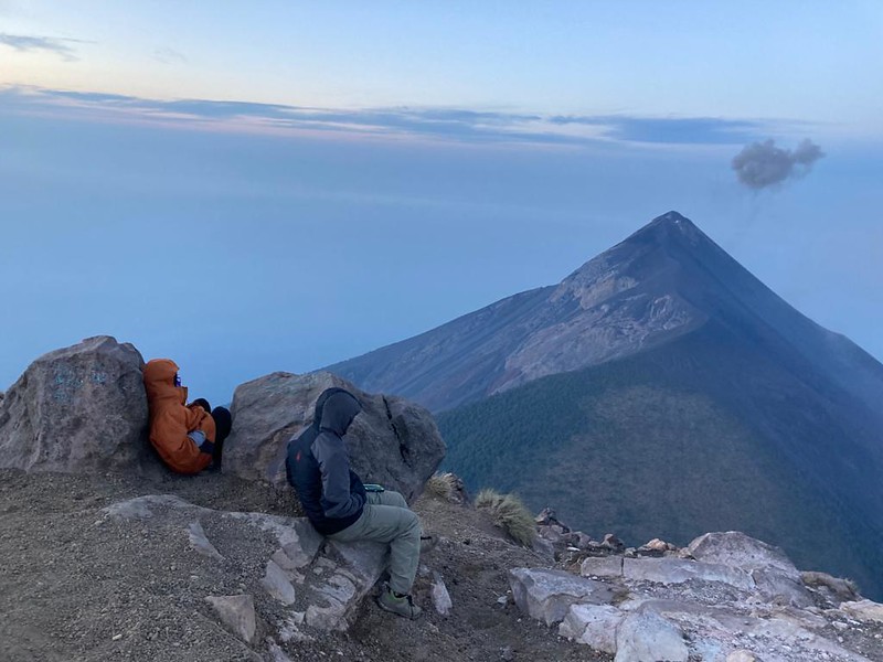 two guys sitting on top of Acatenango volcano