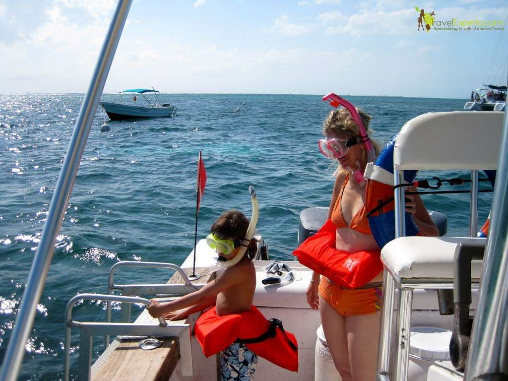 woman a kid on a boat in a snorkeling tour in ambergris caye in belize
