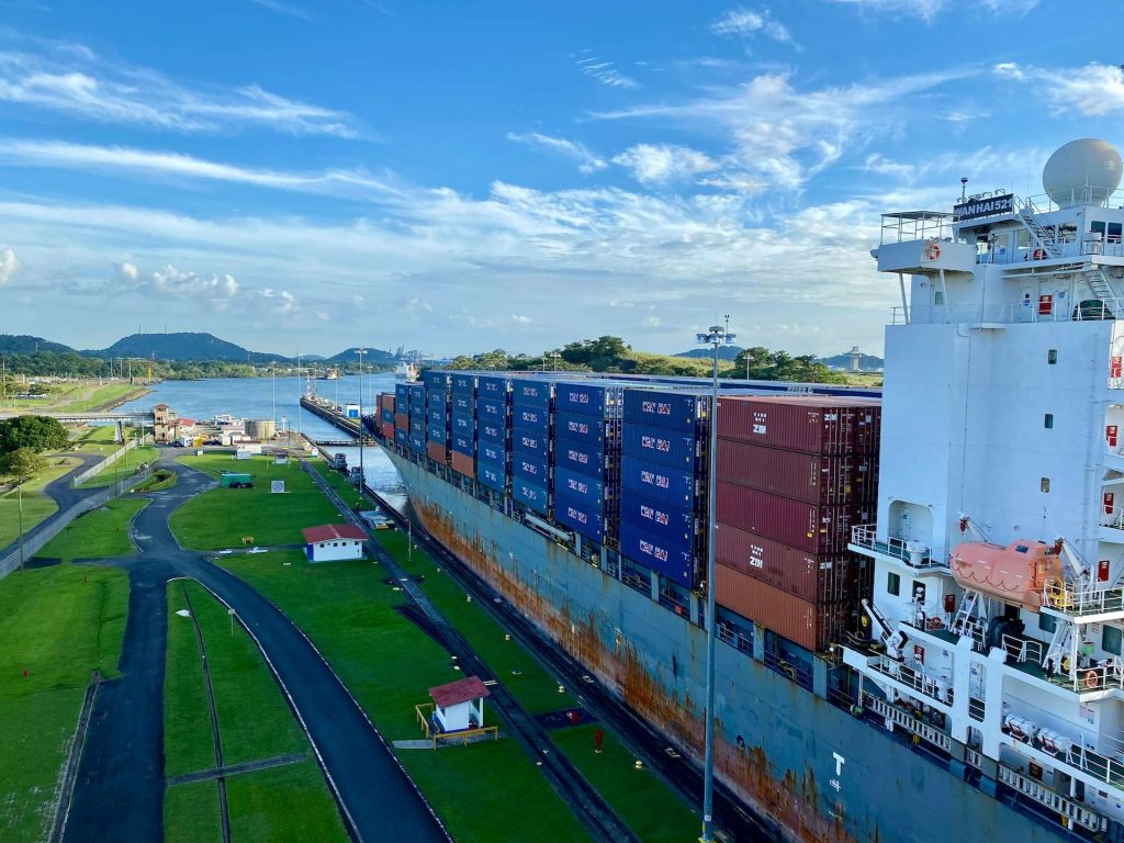 a large boat with containers docked in miraflores dock panama canals