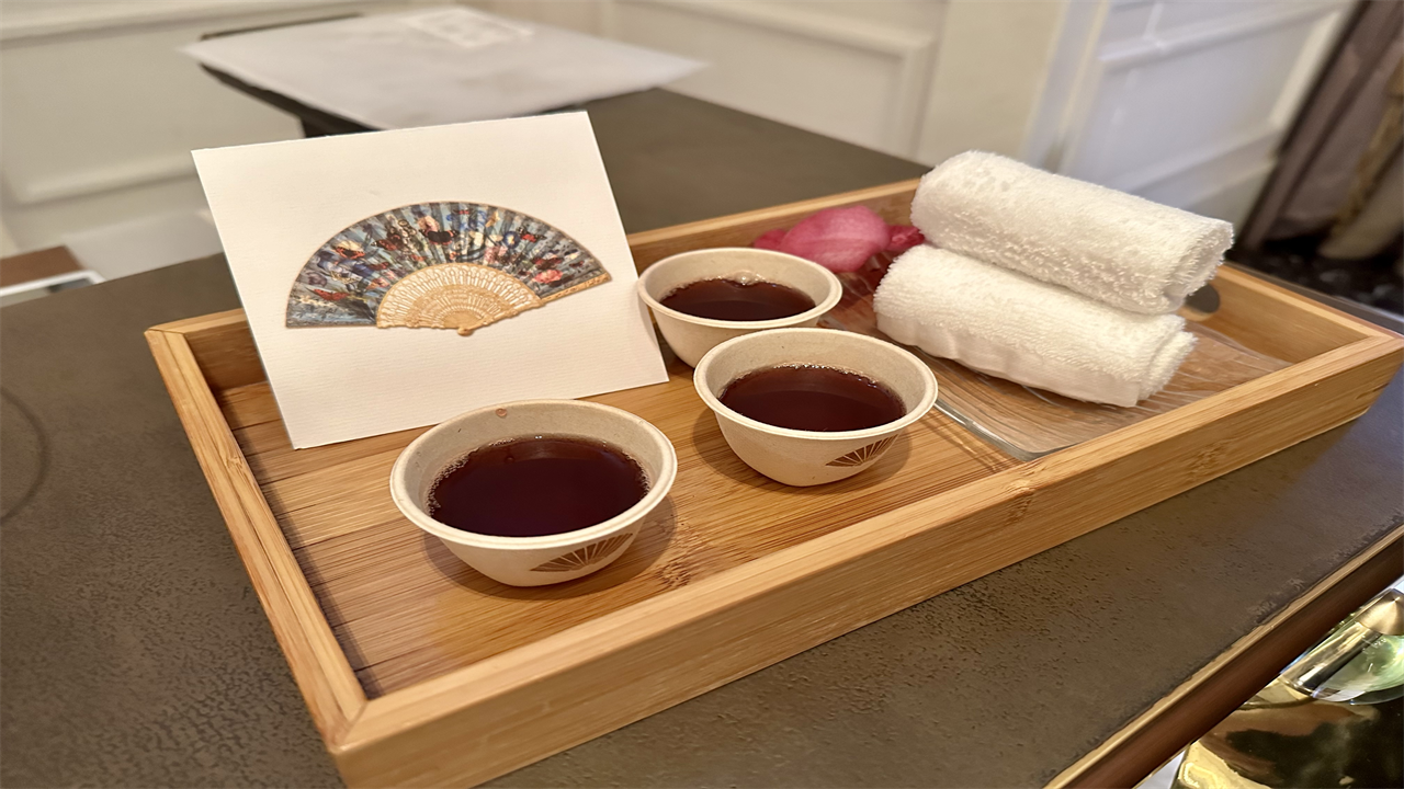 a tray with cups of liquid and towels on it