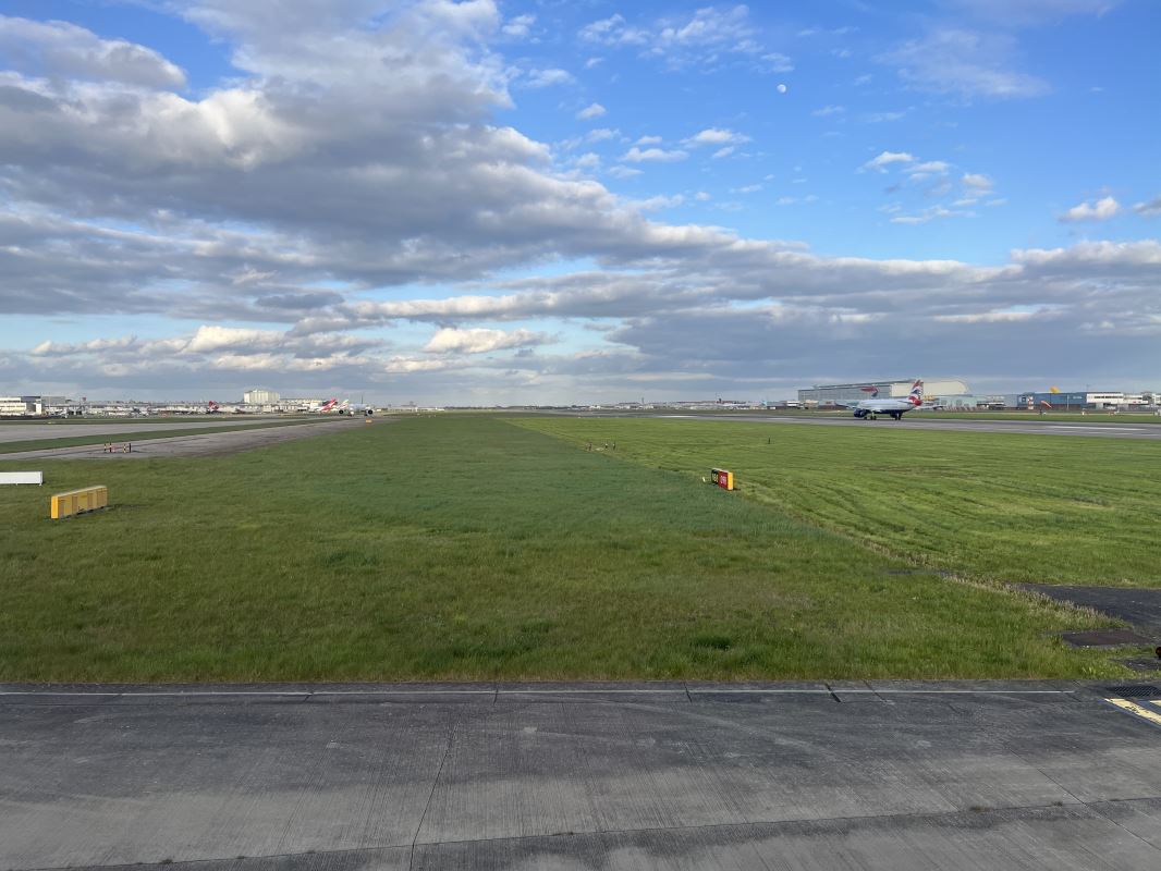 a runway with a plane in the background