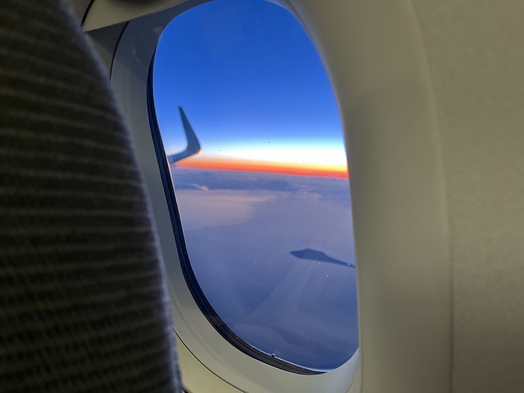 an airplane window with a view of the sky and clouds